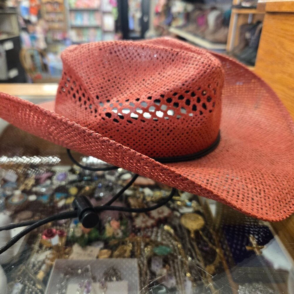 red straw cowboy cowgirl hat with black tie under chin